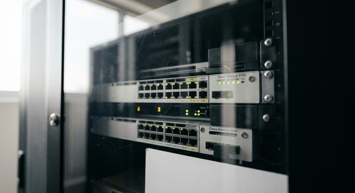 Rack de servidores de Kansas con luces LED parpadeantes detras de un panel de vidrio cerrado en un centro de datos limpio
