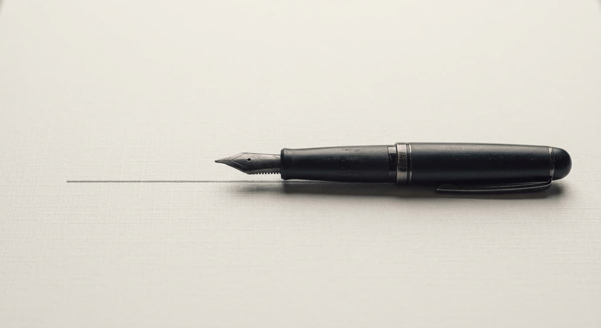 una pluma estilografica apoyada sobre la linea de firma de un documento impreso