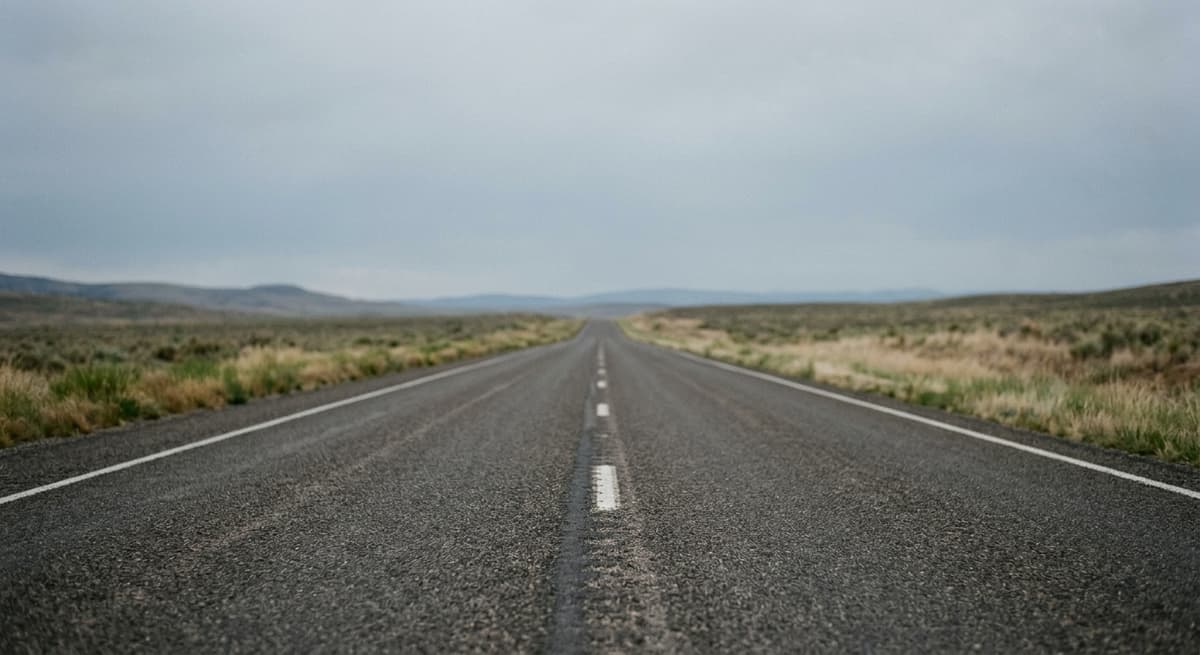 una carretera vacía que se extiende hacia el horizonte bajo un cielo despejado