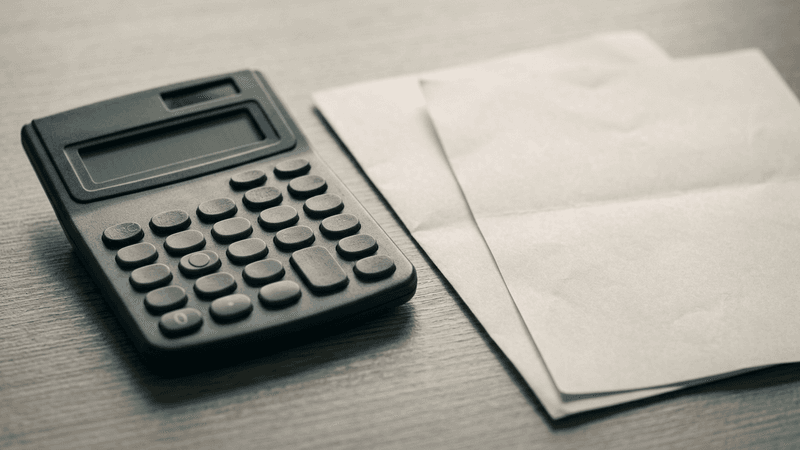calculator beside printed financial statements on a desk