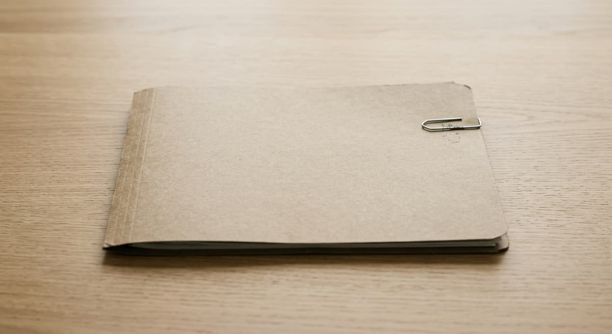 Alabama closed file folder with a single paper clip on a clean light wood desk