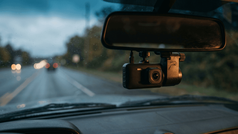 Camara de tablero en Vermont montada detras de un espejo retrovisor dentro de un vehiculo, con la carretera visible al frente