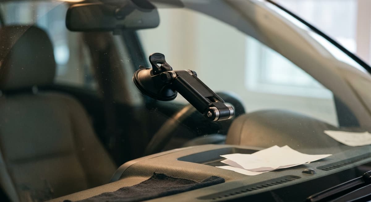 An empty articulated windshield mount arm folded against the glass